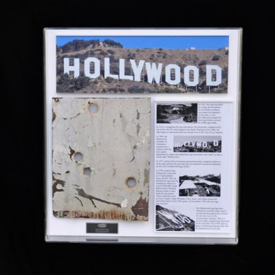 Hollywood Sign
Of all the screen used movie props that exist, the historic Hollywood sign in the hills has been in more movies that any other. It is shown on the front cover of many DVDs, shown in the background in many movie scenes, and even a key prop in others. Hank Berger purchased the original Hollywood sign directly from the Hollywood Chamber of Commerce after its demolition in 1978, and it has remained in storage for over 25 years. Producer Dan Bliss acquired the Hollywood sign from Berger and owns the remaining pieces today. In November 2004, the Hollywood History Museum purchased a large unaltered section of the letter H from Mr. Bliss for $11,766.00. This section is now part of the museum's permanent collection located at the intersection of Hollywood Boulevard and Highland Avenue in Hollywood. At that same time, four other large unaltered pieces were sold at auction to private individuals. This piece was cut from a larger piece and show surface rust, literally layers of paint, and imperfect holes punched into it which helped the sign from wind.
Keywords: Hollywood Sign