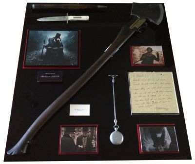 Abe Lincoln Prop Display
When Abraham Lincoln, the 16th President of the United States discovers vampires are planning to take over the United States; he makes it his mission to eliminate them.  This display contains multiple props used in the film by Abraham Lincoln including his Shotgun Axe, Pocket Watch, Stake, Knife, Business Card, and a Letter asking for his help. The main props in the display are stunt versions as the film required multiple action scenes involving stunts that were performed and these specific props were used to minimize possible incidents occurring to the actor when the hero versions would’ve been too dangerous to utilize.
Keywords: Abe Lincoln Prop Display