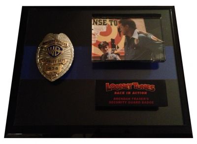 Warner Bros. Studios Security Guard Badge
This is a security officerâ€™s badge from the 2003 film Looney Tunes: Back in Action. This style badge can be seen worn by Warner Bros. Studios guards throughout the film as a former guard (Brendan Fraser) and the Looney Tune characters search for the mythical Blue Monkey Diamond. The metal badge features an eagle with spread wings at top and gold emblems which include the WB logo as well as badge number (438) and â€œAcmeâ€ written across the bottom. 

Keywords: Warner Bros. Studios Security Guard Badge